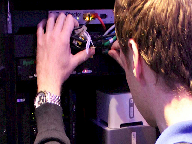 technician installing wiring to a rack mounted smart home system
