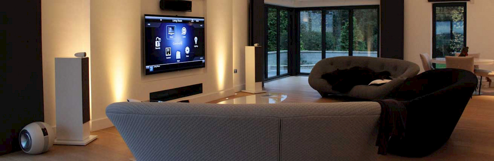 Lounge with 3 sofas tv on the wall above a fireplace in a very modern house