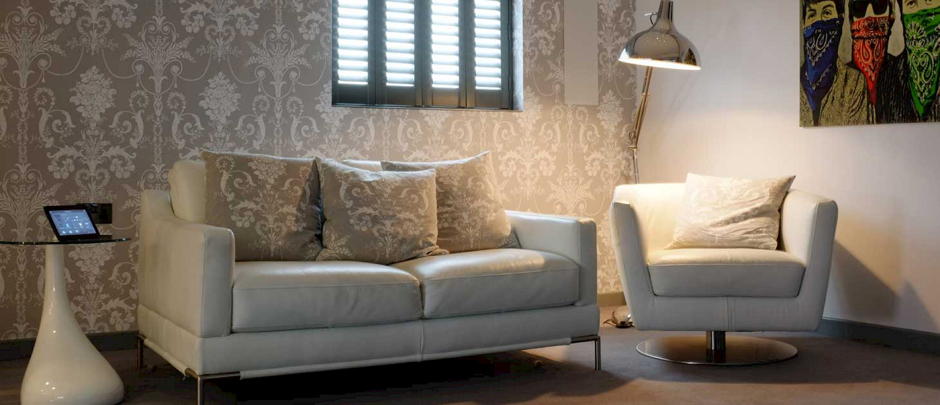 white leather sofa and chair with grey cushions for customers to sit in whilst in the domo room