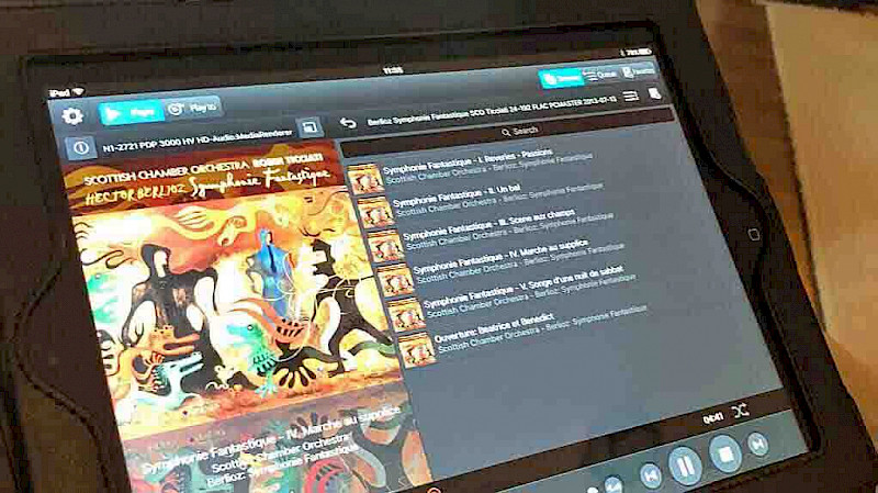 ipad showing online music streaming site, songs available and album artwork and information