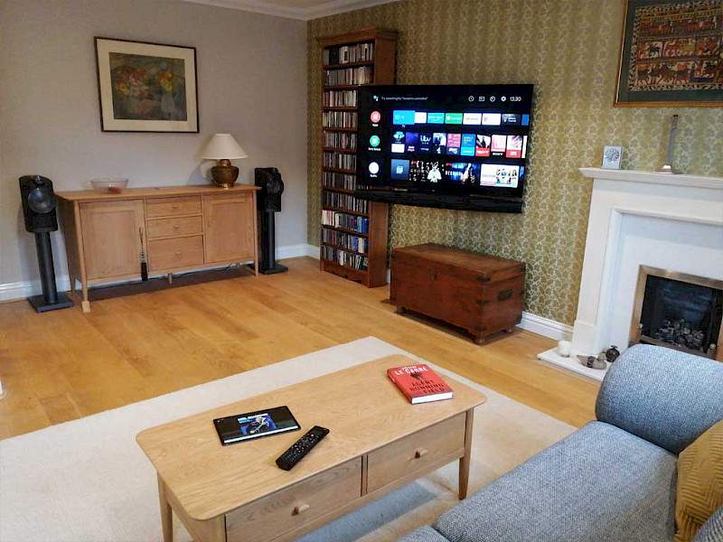 Bowers & Wilkins Formation speakers in a media room plus a large tv on a wall mounted swivel bracket
