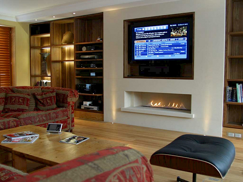 TV mounted in the wall above a fireplace
